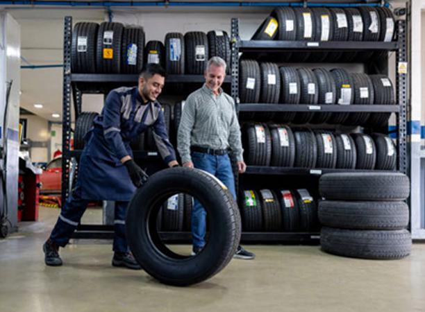 Two man rolling the wheel of the car